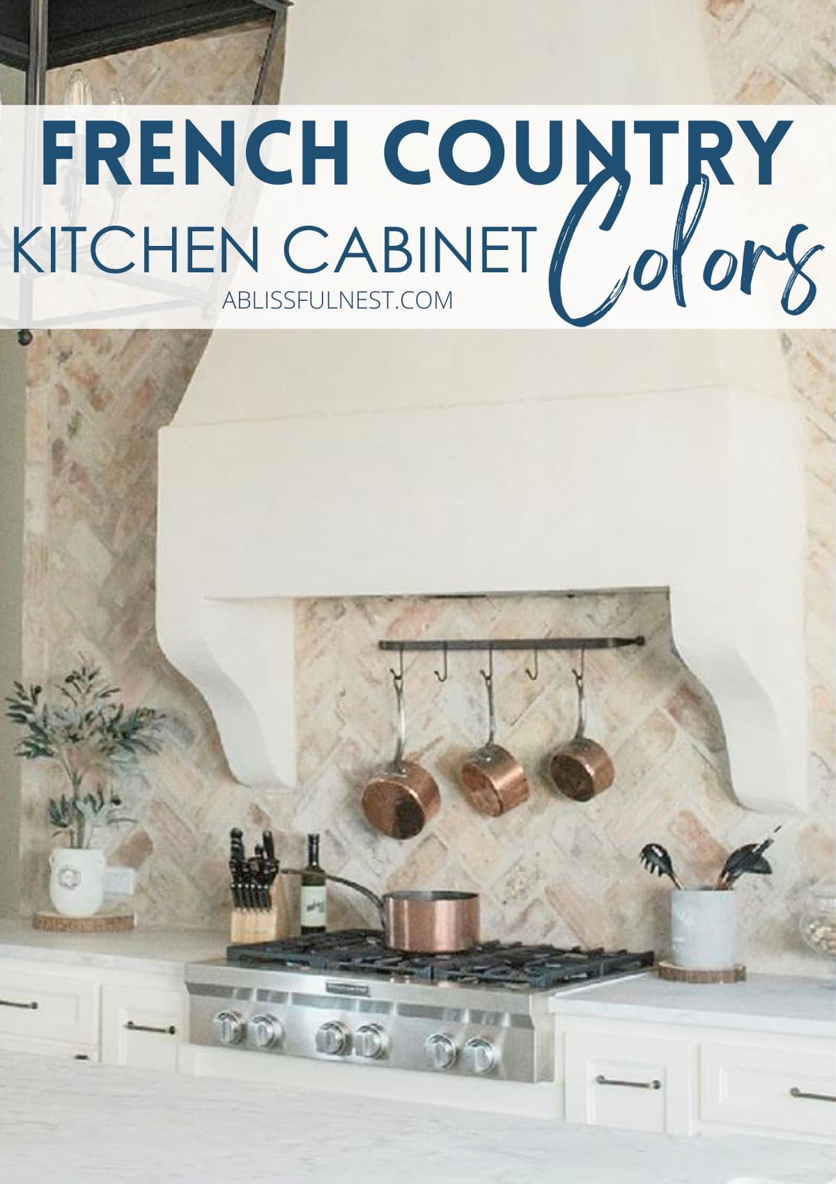 copper pots hanging behind the stove, white kitchen cabinets, brick backsplash