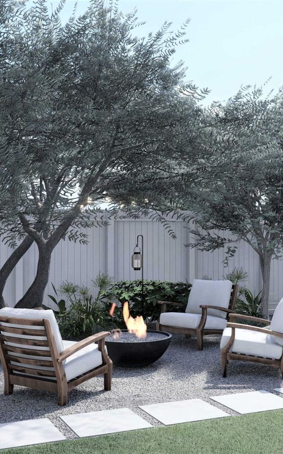 small firepit area with a gravel base and 4 chairs for seating.