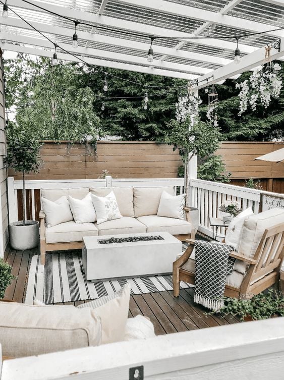 wood patio seating set with a concrete fire pit patio table.